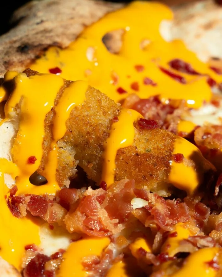 Dettaglio di cheddar, bacon croccante e crocchè