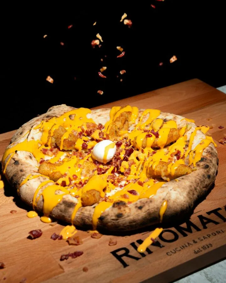Pizza Americana con crocchè, bacon e cheddar sul tagliere Rinomato