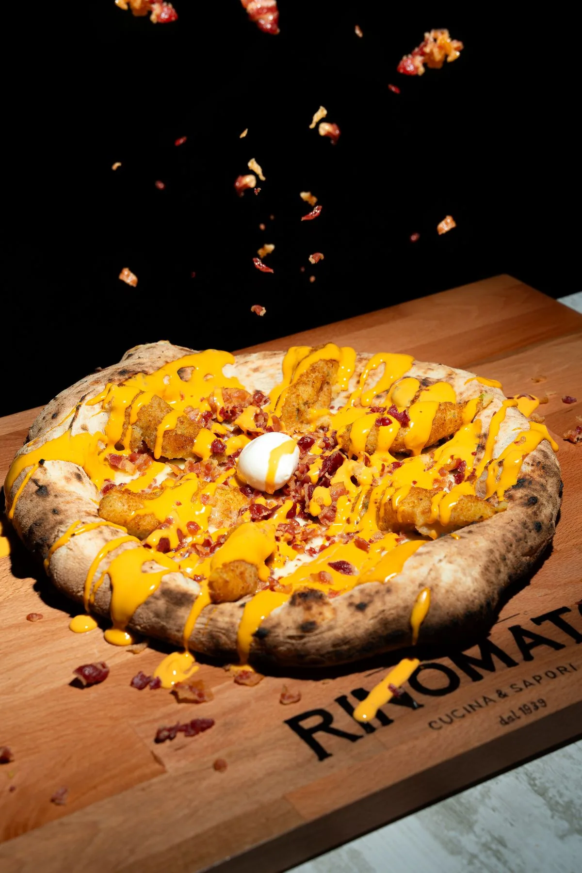Pizza Americana con crocchè, bacon e cheddar sul tagliere Rinomato