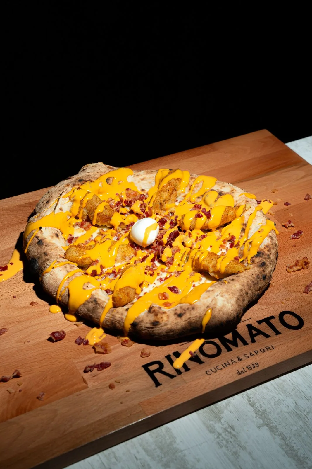 Pizza Americana sul tagliere in legno con logo Rinomato