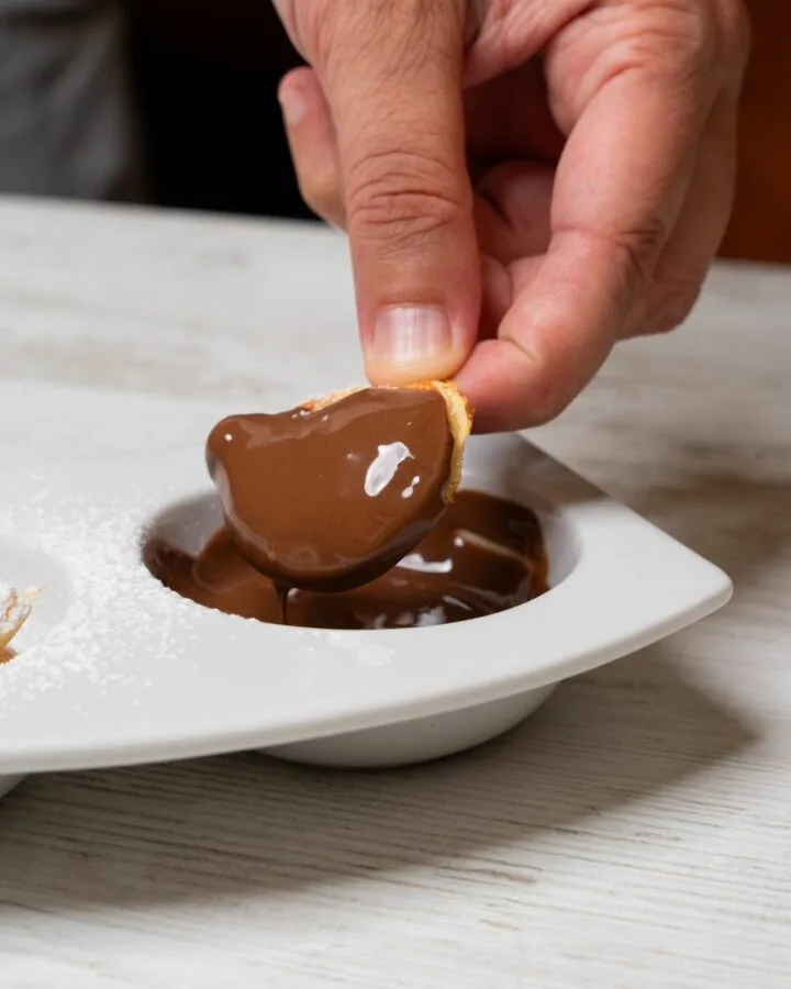 Dolce intinto nella crema al cioccolato