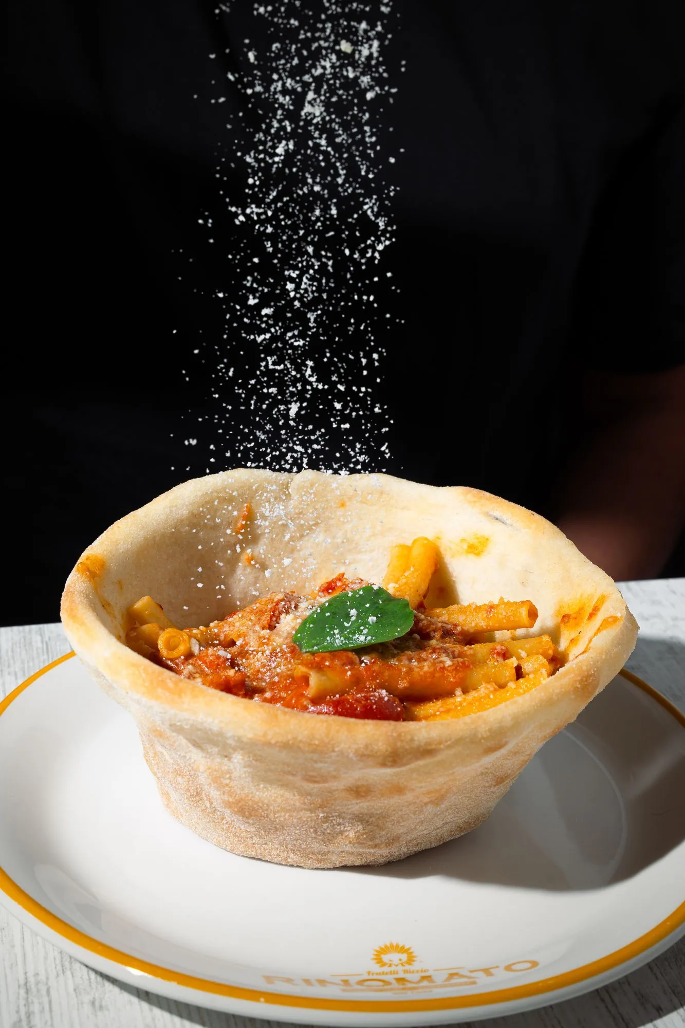 Ziti spezzati allo Scarpariello serviti nel cesto di panpizza, con una pioggia di parmigiano
