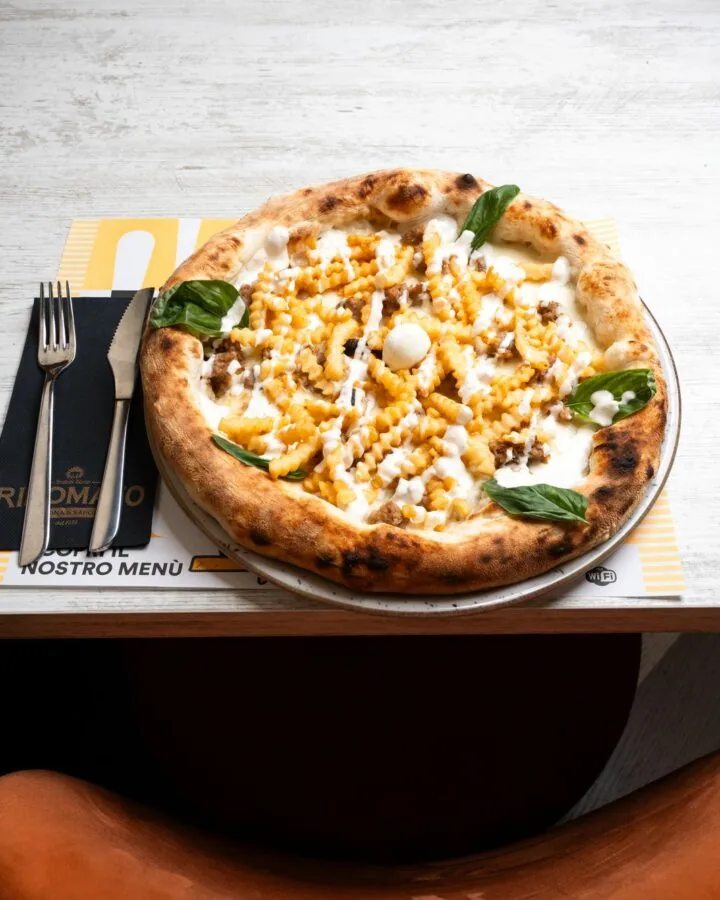 Pizza con patatine zig-zag, servita al tavolo